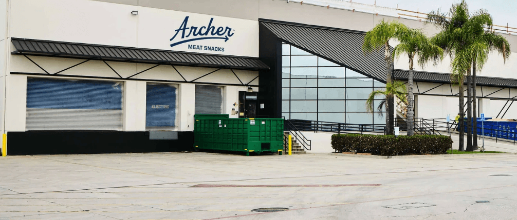 Front of the Archer plant in Vernon — the former Farmer John facility with the Archer Meat Snacks script sign above the entry.